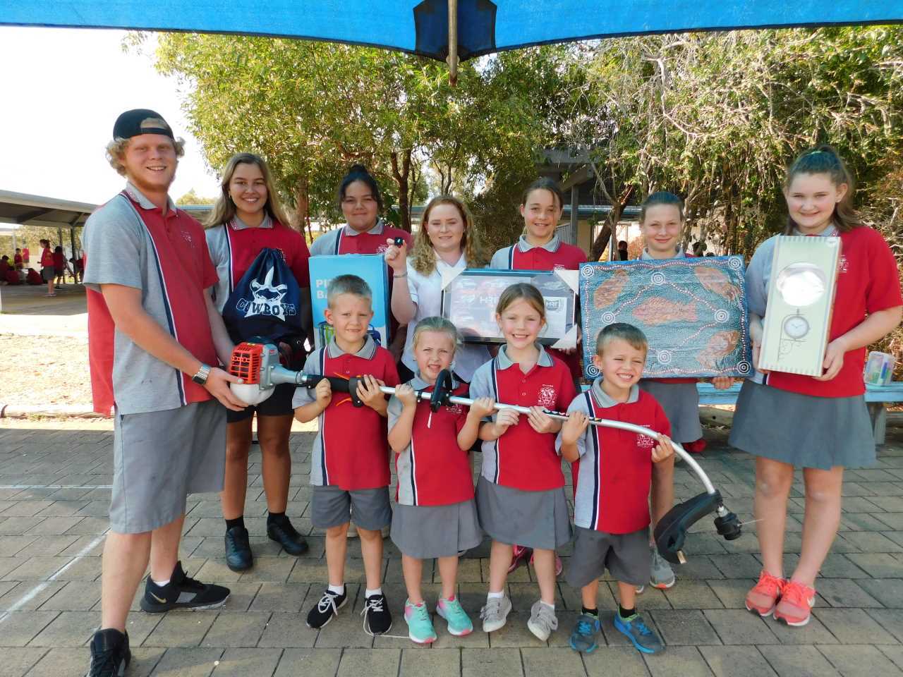 Prep along with the Year 7 and 10 leaders holding some of the awesome auction prizes up for grabs at the Back to the Bay Day 