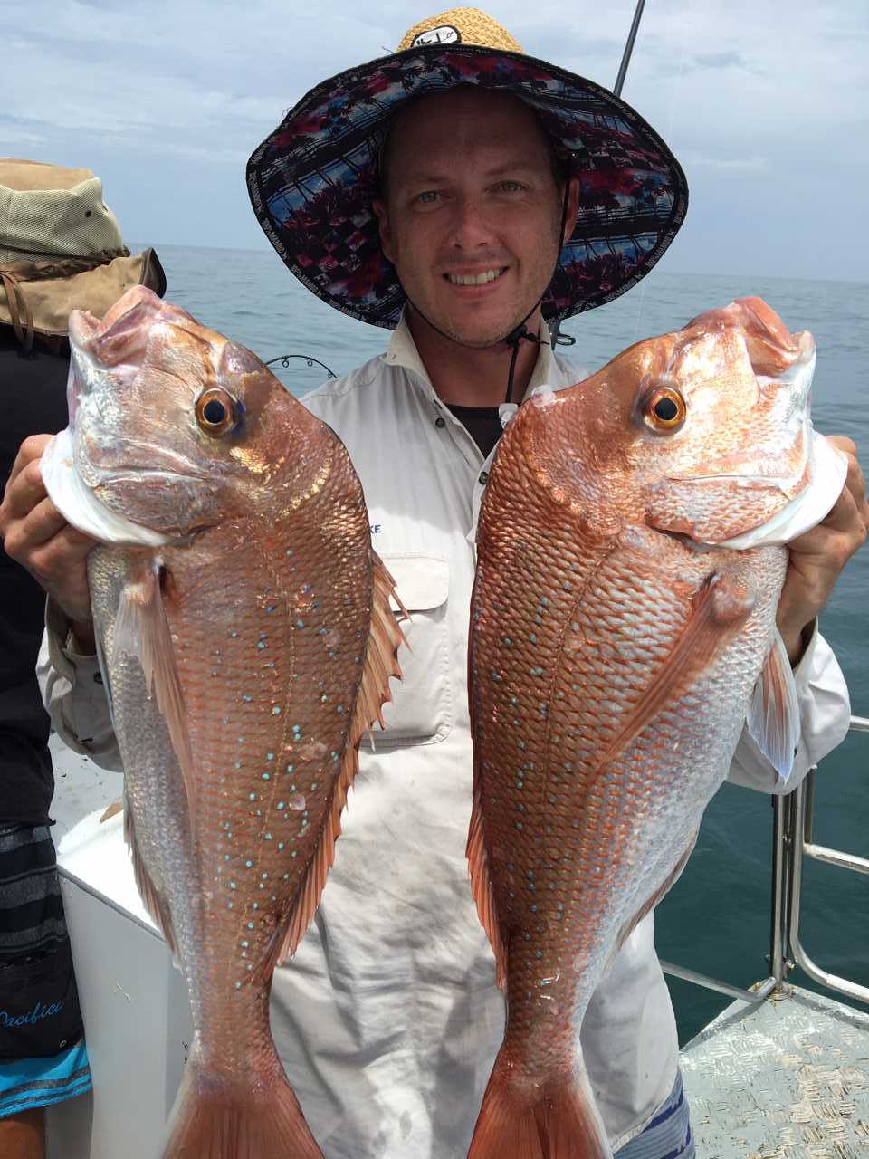 Dan with a pair of snapper with a bagged-out boat