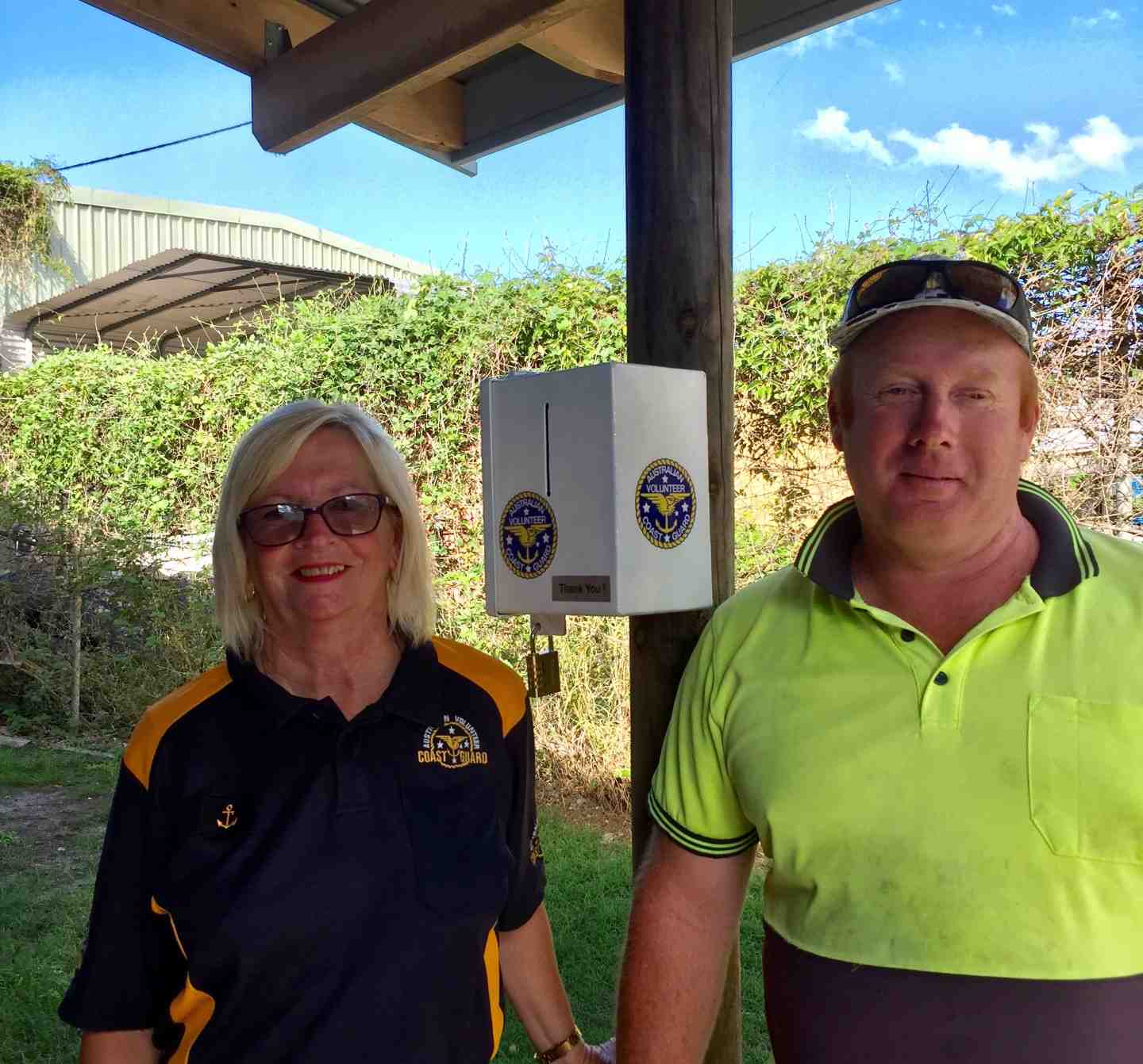Coastguard Purser, Dianne Pryor, commissions the new collection box at Gardiner Fishing with Drew Gardiner - the Coastguard are grateful to all business houses who provide raffle prizes, services free or discounted, or have donation boxes on their counters like this one