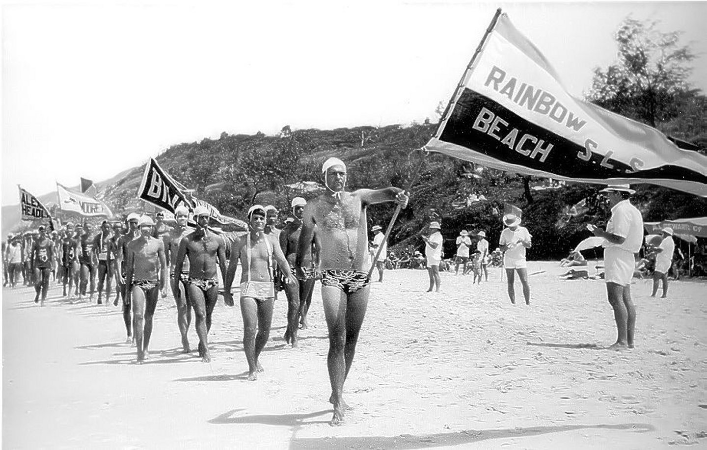 Lofty Wolgast carrying the flag for the club in the first surf carnival ever held at Rainbow Beach in the 1971/1972 season.