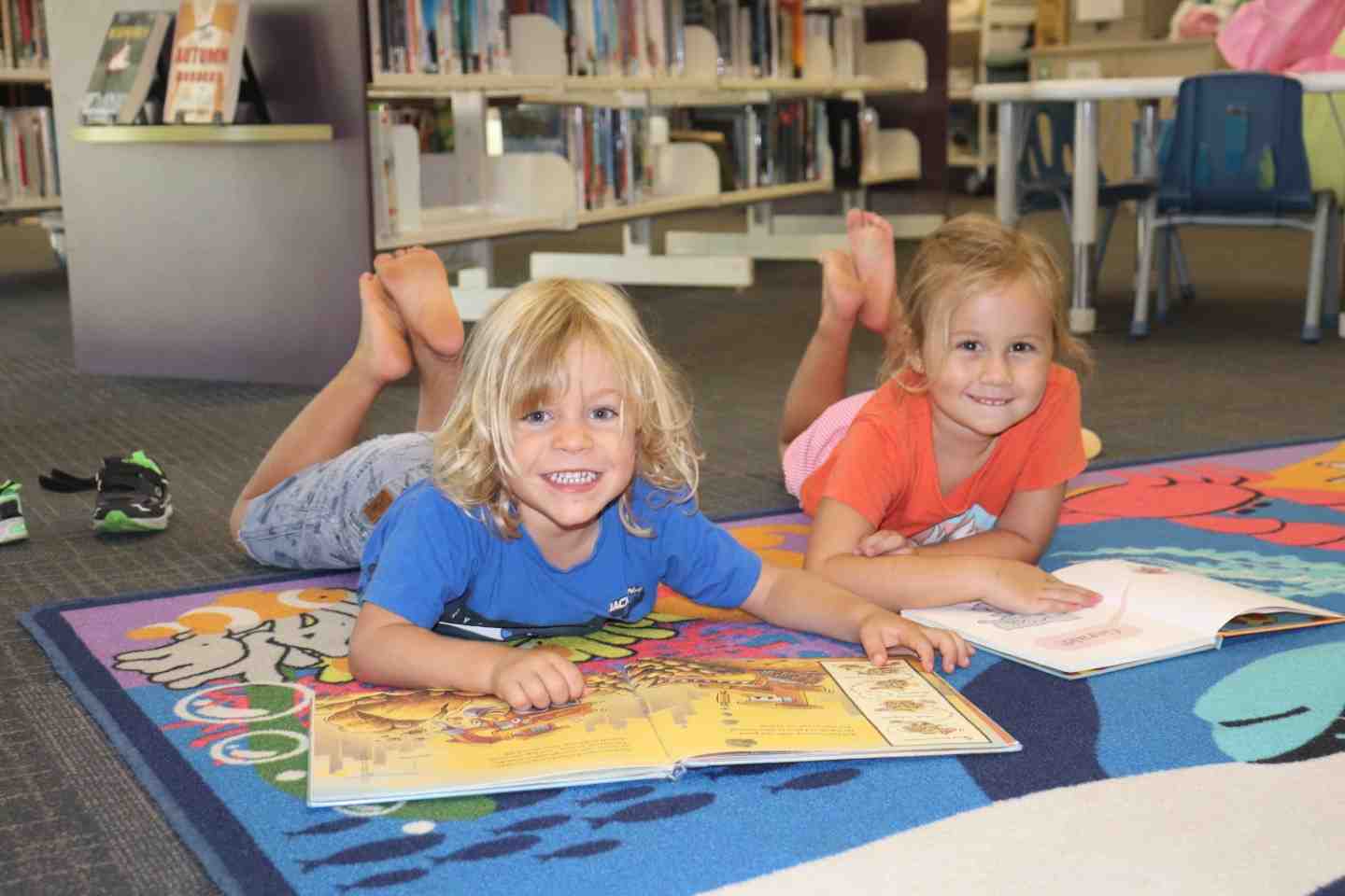 Our libraries have lots on for the school break: Damon and Lelania enjoy a good book at First 5 Forever, Rainbow Beach Library