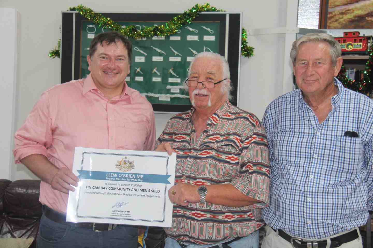 Shed Patron, Llew O’Brien, presenting Shed Manager Bryan Phillips and President Rob Jones, with the certificate through the N