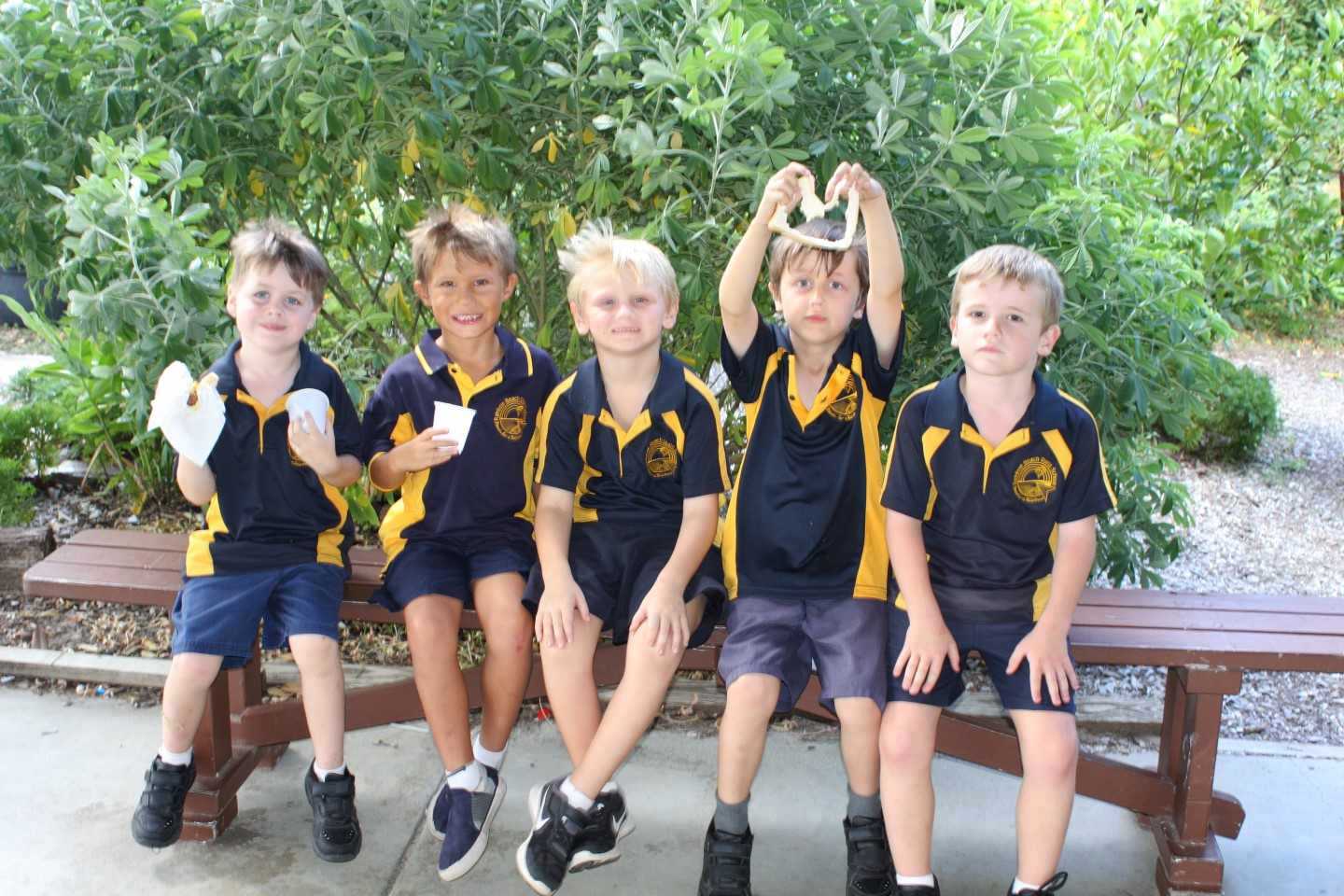 Rainbow Beach State School preppies, Casey, Zay, Roy, Liam and Darcy enjoy a sausage and game of handball at the Welcome BBQ.