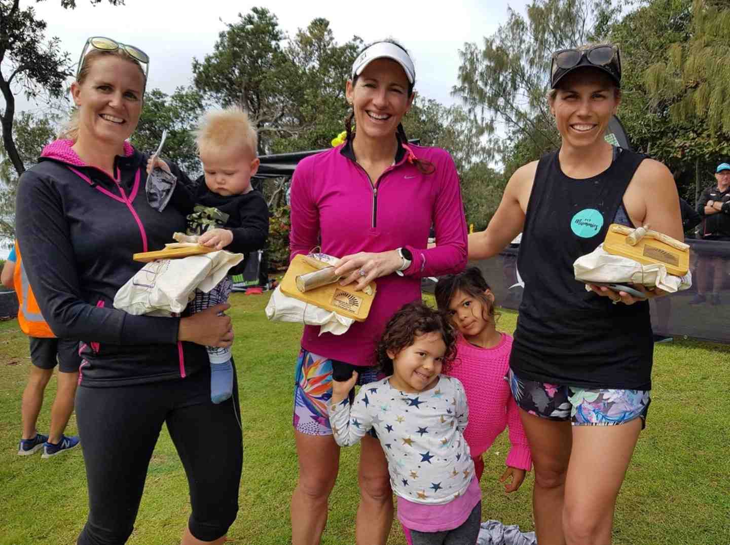 The Rainbow Beach Trail Festival women's half marathon winners Elly Marie, Michelle Bremer and Lauren Ormsby, who were met after the race by their children