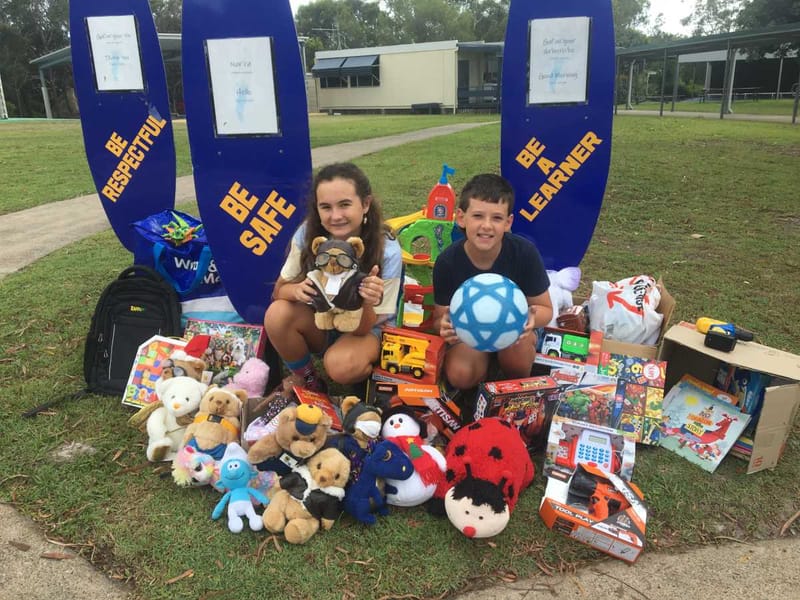 Keira Powers and Oscar Brown-Gram with the pile of donated toys at Rainbow Beach school