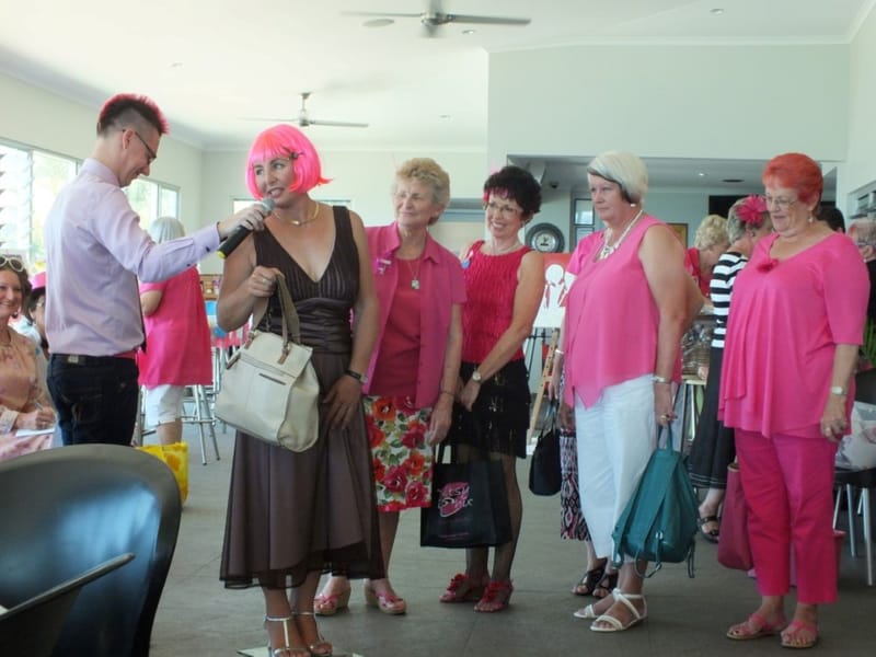 Maree Van Oirshot in the pink wig, with Auctioneer Andrew Hawkins with the Pink Ladies of Rainbow Beach at one of Maree’s Bre