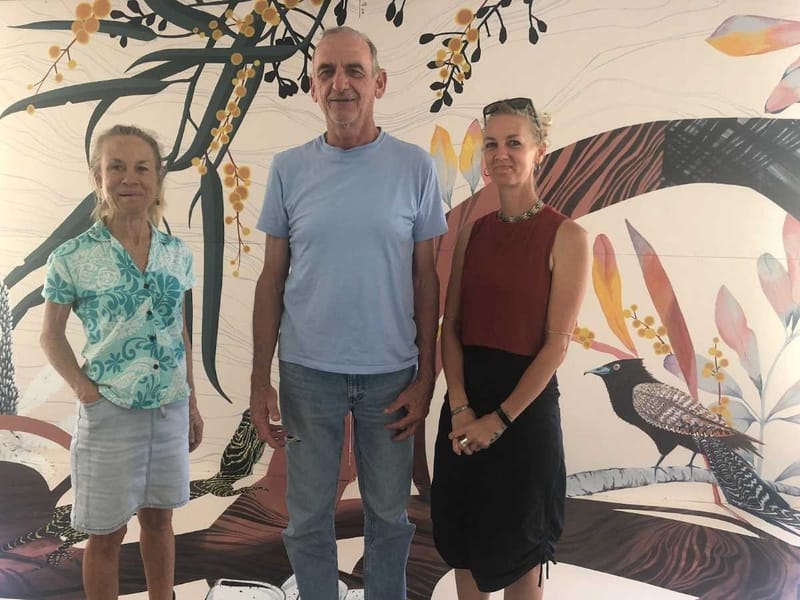 From left, local artists Mo Riggs and Scott Taylor with mural artist EJ Zyla in front of the workshop mural. Photo credit: De