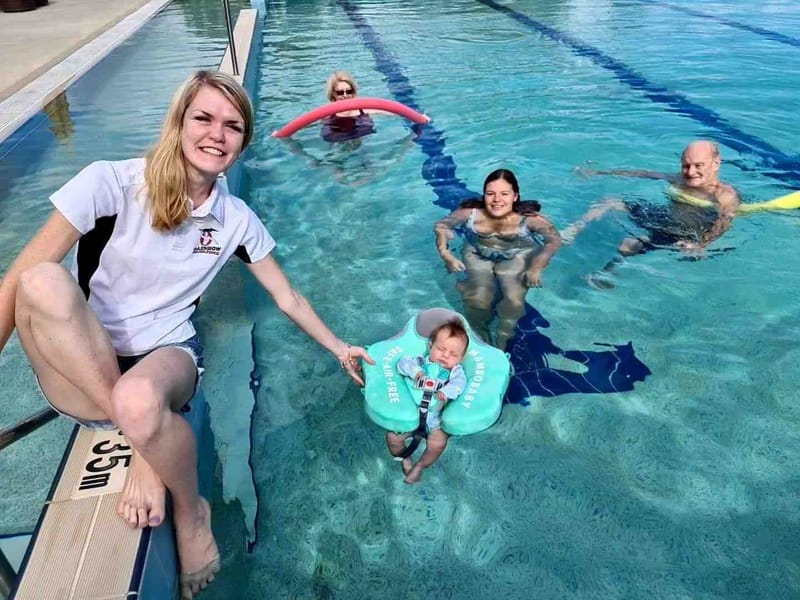 Kyani Parton helping Chris and Bryan Smith and Georgia and baby Banksia get the most of their time in the newly reopened pool