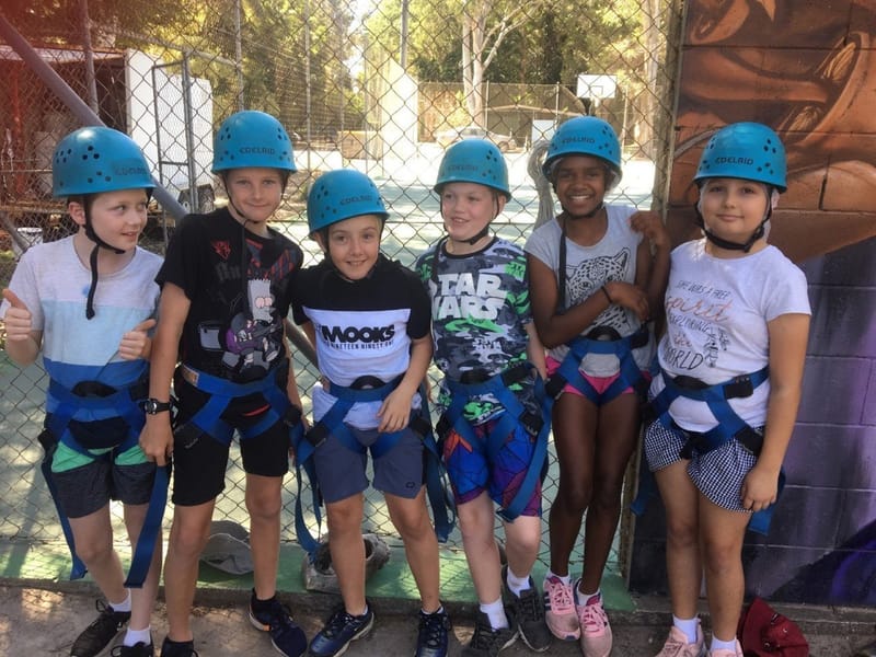 Students preparing for abseiling, then enjoying the pool afterwards